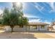 Quaint single-story house with a charming exterior and mature shade tree in the front yard at 2227 W Paradise Dr, Phoenix, AZ 85029