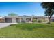 Charming single-story home featuring a well-maintained lawn, brick accents, and attached garage at 2527 N 69Th Pl, Scottsdale, AZ 85257