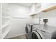 Bright laundry room with new washer and dryer, with lots of storage shelves at 2527 N 69Th Pl, Scottsdale, AZ 85257