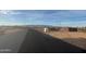 Empty lot ready for development, featuring a retaining wall and distant mountain views at 28304 N 220Th Ave, Wittmann, AZ 85361