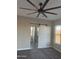 Main bedroom with barn door to bathroom, ceiling fan, and carpet at 28304 N 220Th Ave, Wittmann, AZ 85361
