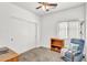 Comfortable carpeted bedroom featuring a ceiling fan, natural light, and a relaxing blue accent chair at 2865 E Cathy Dr, Gilbert, AZ 85296