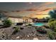 Expansive backyard with a pool, hot tub, covered patio, and desert-style landscaping at 30696 N 130Th Ln, Peoria, AZ 85383