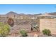 Landscaped wall with desert themed metal art with view of a distant neighborhood and mountains at 30696 N 130Th Ln, Peoria, AZ 85383