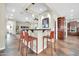 This bar features a stone countertop and three bar stools, situated within an open floorplan at 30696 N 130Th Ln, Peoria, AZ 85383