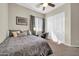 Bedroom featuring neutral walls, a ceiling fan, and a large window with curtains offering natural light at 30696 N 130Th Ln, Peoria, AZ 85383