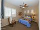 Cozy bedroom with a ceiling fan and rocking chair at 30696 N 130Th Ln, Peoria, AZ 85383