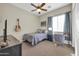 Bedroom featuring neutral walls, a ceiling fan, a TV, and a desk, offering a comfortable space at 30696 N 130Th Ln, Peoria, AZ 85383