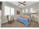 Cozy bedroom with a blue bed, ceiling fan, and rocking chair offering a relaxing retreat at 30696 N 130Th Ln, Peoria, AZ 85383