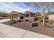 Single-story home with three-car garage, mature tree, and gravel landscaping at 30696 N 130Th Ln, Peoria, AZ 85383