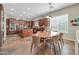 A full view of the kitchen island, wooden cabinets, stainless steel appliances, and dining table, within an open floorplan at 30696 N 130Th Ln, Peoria, AZ 85383