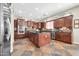 Spacious kitchen with stainless steel appliances, dark wood cabinetry, and a large central island at 30696 N 130Th Ln, Peoria, AZ 85383