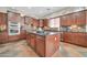 This kitchen features a central island with dark countertops and wooden cabinets, and stainless steel appliances at 30696 N 130Th Ln, Peoria, AZ 85383