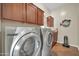 Efficient laundry room with a washer and dryer, built-in cabinets, and tiled flooring for easy cleaning at 30696 N 130Th Ln, Peoria, AZ 85383