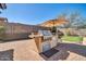 Outdoor kitchen and bar area features a stainless steel barbecue, counter space and seating at 30696 N 130Th Ln, Peoria, AZ 85383