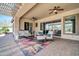 Outdoor living space with comfortable seating, ceiling fans, and sliding doors to the home's interior at 30696 N 130Th Ln, Peoria, AZ 85383