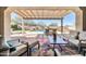 Inviting covered patio overlooking a pool with comfortable seating and a stylish outdoor rug at 30696 N 130Th Ln, Peoria, AZ 85383