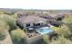 Backyard aerial view with a pool, a covered patio seating area, and desert landscaping at 30696 N 130Th Ln, Peoria, AZ 85383
