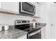 Close up of the stainless steel stove with granite countertops and white cabinets at 3508 N Preston St, Casa Grande, AZ 85122