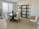Dining area with a wooden table, white chairs, and a stylish shelving unit at 39190 N Kaden Ln, San Tan Valley, AZ 85140