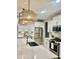 Modern kitchen with white cabinets, quartz countertops, and stainless steel appliances at 39190 N Kaden Ln, San Tan Valley, AZ 85140