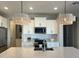 Modern kitchen with white cabinets, quartz countertops, and stainless steel appliances at 39190 N Kaden Ln, San Tan Valley, AZ 85140