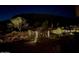 Night view of a well-lit backyard featuring desert landscaping and mountain views at 5000 N Camelback Ridge Dr # 107, Scottsdale, AZ 85251
