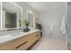 Modern bathroom with double sinks, lighted mirrors, and a glass shower at 5000 N Camelback Ridge Dr # 107, Scottsdale, AZ 85251