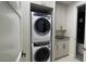 Modern laundry room with stacked washer and dryer, and built-in cabinets at 5000 N Camelback Ridge Dr # 107, Scottsdale, AZ 85251