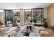 Bright living room with hardwood floors, white sofas and a sliding glass doors to bring in the outside view at 5000 N Camelback Ridge Dr # 107, Scottsdale, AZ 85251