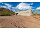 View of home exterior with large garage, covered porch, and desert landscape on a cloudy day at 5465 N Winchester Rd, Apache Junction, AZ 85119