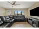 Living room with sectional sofa, wood-look floors, and ceiling fan at 730 W El Alba Way, Chandler, AZ 85225