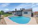 Backyard pool with a brown covered patio, grassy area and block fence at 7331 W Aster Dr, Peoria, AZ 85381