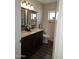 Bathroom featuring a double sink vanity with granite countertop and wood look flooring at 7331 W Aster Dr, Peoria, AZ 85381