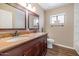 Bathroom with double sink vanity, wood-look floors, a window and a toilet at 7331 W Aster Dr, Peoria, AZ 85381