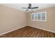 Bright bedroom features wood-look floors, neutral paint, a ceiling fan and a window with white blinds at 7331 W Aster Dr, Peoria, AZ 85381