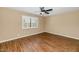 Bedroom featuring wood flooring, plantation shutters, and a ceiling fan at 7331 W Aster Dr, Peoria, AZ 85381