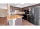 Modern kitchen with sleek countertops, stainless steel appliances, dark cabinetry and wood floors at 7331 W Aster Dr, Peoria, AZ 85381