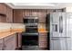 Kitchen with stainless steel appliances and dark wood cabinets and granite countertops at 7331 W Aster Dr, Peoria, AZ 85381