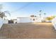 Spacious backyard with modern white home, privacy fence, and desert landscaping at 7860 E Davenport Dr, Scottsdale, AZ 85260