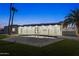 Exterior view of the backyard featuring a pristine pool, modern white house, and manicured lawn at twilight at 7860 E Davenport Dr, Scottsdale, AZ 85260