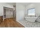 Modern bathroom features a soaking tub, glass enclosed shower, and a walk-in closet at 7860 E Davenport Dr, Scottsdale, AZ 85260