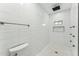 Modern bathroom featuring white tile, a shower with black fixtures, and hexagonal shower floor tiling at 7860 E Davenport Dr, Scottsdale, AZ 85260