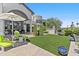 Lush backyard of a property with decorative lawn, a stone tile patio, and beautiful patio seating at 10120 E Topaz Dr, Scottsdale, AZ 85258