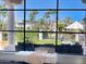 Backyard view from inside home with patio seating overlooking grassy area, water, and palm trees at 10120 E Topaz Dr, Scottsdale, AZ 85258