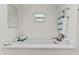 Modern bathroom features a bathtub with white tile surround, decorative towels, and updated fixtures at 10120 E Topaz Dr, Scottsdale, AZ 85258