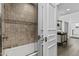 Stylish bathroom featuring tub with tiled walls and a glass door, a view to the bedroom at 10120 E Topaz Dr, Scottsdale, AZ 85258