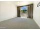 Bright bedroom featuring a large arched window, neutral carpet, and abundant natural light at 10120 E Topaz Dr, Scottsdale, AZ 85258