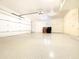 Clean and spacious garage with epoxy flooring, storage cabinets, and an automated door opener at 10120 E Topaz Dr, Scottsdale, AZ 85258