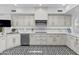 Kitchen featuring white cabinets, tile backsplash, stainless steel appliances, and black and white patterned flooring at 10120 E Topaz Dr, Scottsdale, AZ 85258